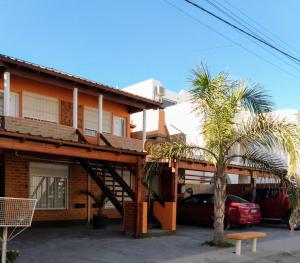 a house with palm trees in front of it at LucyPass Acuario in Las Grutas