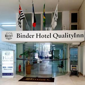 een bord voor een hotel met vlaggen in een gebouw bij Hotel Binder Quality Inn in Mogi das Cruzes