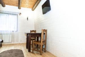 stół i krzesło w pokoju z białą ceglaną ścianą w obiekcie Wood House w mieście Pilipets