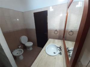 uma casa de banho com um lavatório, um WC e um espelho. em Hotel Mitre Chivilcoy. Casa en Rivadavia 900 em Chivilcoy
