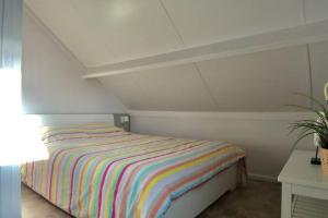 Un dormitorio con una cama con una manta a rayas. en ZeeZonZand, en Koksijde 23 fotos más