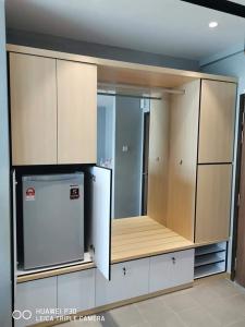 a kitchen with wooden cabinets and a refrigerator at Cozy Seaview Studio at Imperium residence Tanjung Lumpur Kuantan in Kuantan