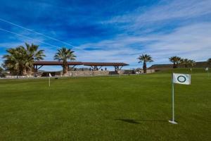 un segno nel mezzo di un campo verde con palme di Villa de Murcia - Relaxing Villa with Private Pool a Murcia