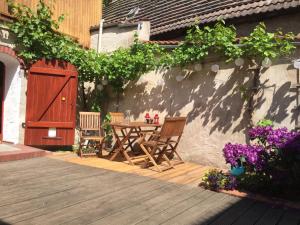 een houten terras met een tafel, stoelen en bloemen bij Radler Pension Wettin in Wettin