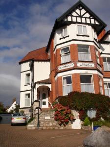 a large brick building with flowers in front of it at Beachmount Holiday Apartments in Colwyn Bay