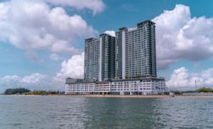 a large building on the shore of a body of water at Cozy Seaview Studio at Imperium residence Tanjung Lumpur Kuantan in Kuantan