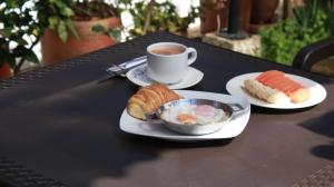 a table with two plates of food and a cup of coffee at Villa Pepita Real in Villa de Leyva