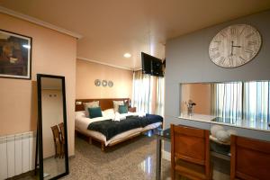 a bedroom with a bed and a clock on the wall at H. O Lar in O Barco de Valdeorras