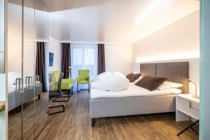 a bedroom with a bed and a desk and chairs at Hotel Rischli in Sörenberg