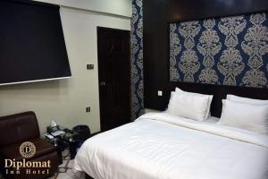 a bedroom with a large white bed with a blue wall at Karachi Guest House in Karachi