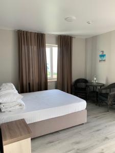 Un dormitorio con una cama grande y una ventana en Foton Hotel & Restaurant en Ochakiv