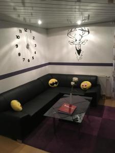 - un salon avec un canapé et un réveil sur le mur dans l'établissement Haus Zeichner 4 Zimmer Ferienwohnung, à Feldberg