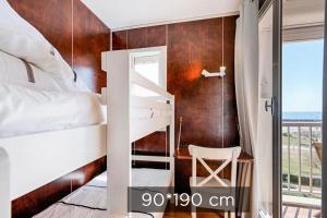 una camera da letto con un letto a castello e una scrivania di Vue mer à la plage du Môle - Clim - Fibre Wifi a Cap d'Agde