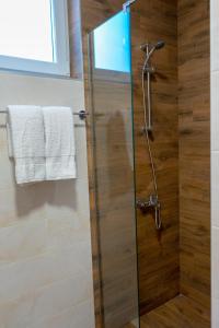 um chuveiro com uma porta de vidro na casa de banho em Apartman Tuscany em Sokobanja