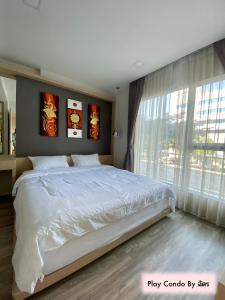 1 dormitorio con cama grande y ventana grande en Play Condo Chiang mai MAYA en Chiang Mai