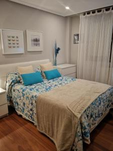 リャネスにあるApartamento de Toróのベッドルーム(青い枕の大型ベッド1台付)