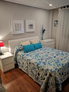 1 dormitorio con 1 cama con almohadas azules en Apartamento de Toró, en Llanes