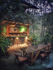 a table and chairs in front of a bar at Eco Quechua Lodge in Santa Teresa
