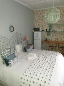 1 dormitorio con 1 cama blanca grande con almohadas en Blue Rain Guest House, en Upington
