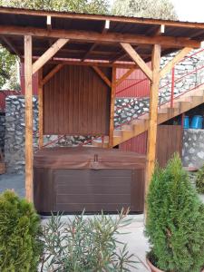 a wooden pergola with a garage under it at Mónika Vendégház in Egerszalók