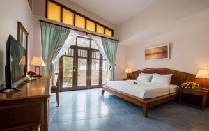 una camera da letto con un letto e una TV in una stanza di Lazi Beach Resort a La Gi