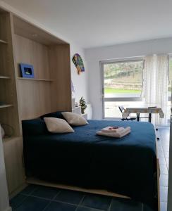 a bedroom with a large bed and a table at Appartement plage de Kerfany les Pins in Moëlan-sur-Mer