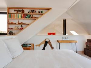 Un dormitorio con una cama blanca y una escalera. en The Artists House by The Sea, en Herne Bay