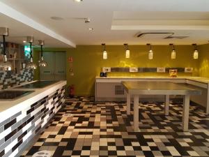 a kitchen with a table and a checkered floor at Holiday Inn Luton South - M1, Junction 9, an IHG Hotel in Luton