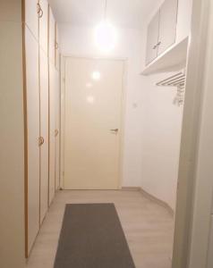 a hallway with a white door and a rug at Koskentien yksiö in Jämsä