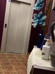 a table with a blue vase with a plant on it at Alcaidia De Magina in Cambil