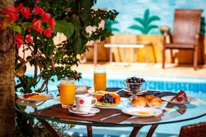 a table with breakfast foods and drinks on it at Jardim dos Orixás in Canoa Quebrada