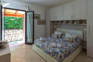 a bedroom with a bed and a sliding glass door at Elbaloves Appartaments Villa in Capoliveri
