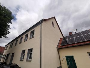 a building with solar panels on top of it at Urlaub am Mittelpunkt. Neue Ferienwohung im alten Mehlager in Niederdorla