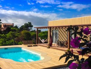 - une piscine sur une terrasse en bois à côté d'une maison dans l'établissement El Diablo y el Mar, à Punta del Diablo
