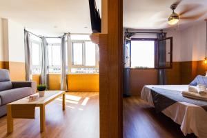 ein Zimmer mit einem Bett, einer Couch und einem Tisch in der Unterkunft Coral Friendly Holiday Home in Playa del Ingles + 35 Fotos