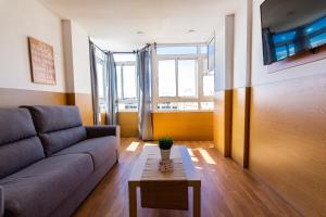 ein Wohnzimmer mit Sofa und Tisch in der Unterkunft Coral Friendly Holiday Home in Playa del Ingles