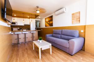 ein Wohnzimmer mit Sofa und Tisch in der Unterkunft Coral Friendly Holiday Home in Playa del Ingles