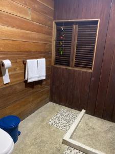 a bathroom with wooden walls and a window with towels at playa mecana kirita in Bahía Solano