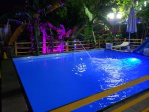 ein Pool, der nachts blau leuchtet in der Unterkunft Itaparica - Vera Cruz 12 pessoas in Vera Cruz de Itaparica