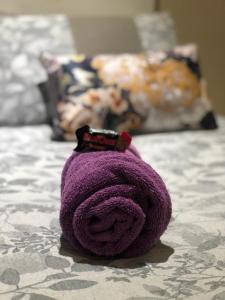 un animal de peluche púrpura sentado en una cama en Rest and Rise, en Pietermaritzburg