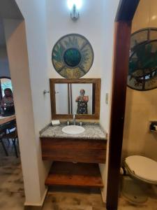 a bathroom with a sink and a mirror at Praia das Cigarras São Sebastião a 50 metros da praia - Wi-Fi - 500 Mega in São Sebastião