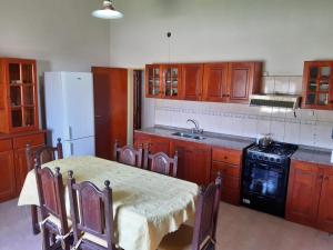 uma cozinha com uma mesa, um fogão e um frigorífico em Hotel Mitre Chivilcoy. Casa en Rivadavia 900 em Chivilcoy