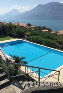 a large blue swimming pool with a view of the water at Appartamento Venzo in Brenzone sul Garda