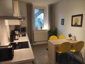 a kitchen with yellow chairs and a kitchen table at Apartment Philosophenviertel in Hannover