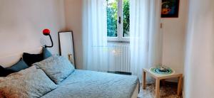 ガエータにあるLa casa di Ulisseの青いベッドと窓のある寝室