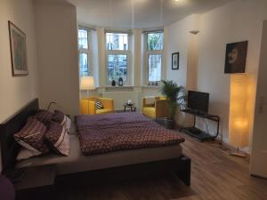 ein Schlafzimmer mit einem Bett und ein Wohnzimmer mit Fenstern in der Unterkunft Apartment Philosophenviertel in Hannover