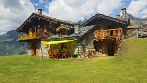 a house on a hill with a table and chairs at Chalet Le Lis in Valtournenche