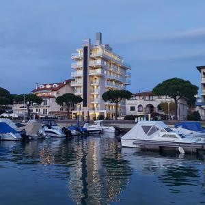 eine Gruppe von Booten, die in einem Hafen mit einem Gebäude angedockt sind in der Unterkunft Hotel Mare in Lignano Sabbiadoro