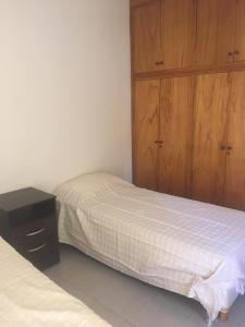 Departamento Serpa في سيوداد لوجان دي كويو: غرفة نوم بسريرين وخزانة خشبية