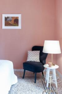 サレルノにあるStarhost - CHEZ MAMIEのベッドルーム(椅子、ランプ付きテーブル付)